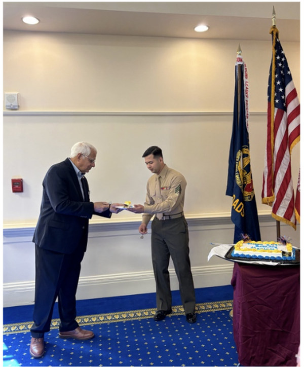 The oldest Marine present, Col. Dennis Garcia, USMC (Ret.) (l), passes the piece of cake to the youngest Marine present, Sgt. Joseph Bonilla (r) during the chapter's cake-cutting ceremony in November.